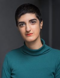 A headshot of a student in a teal turtleneck top with cropped black hair