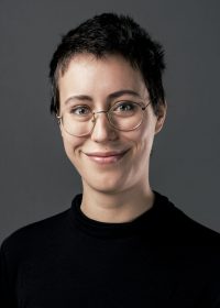 Headshot of woman with short dark hair and round glasses