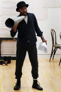 Actor in rehearsals, holding a megaphone